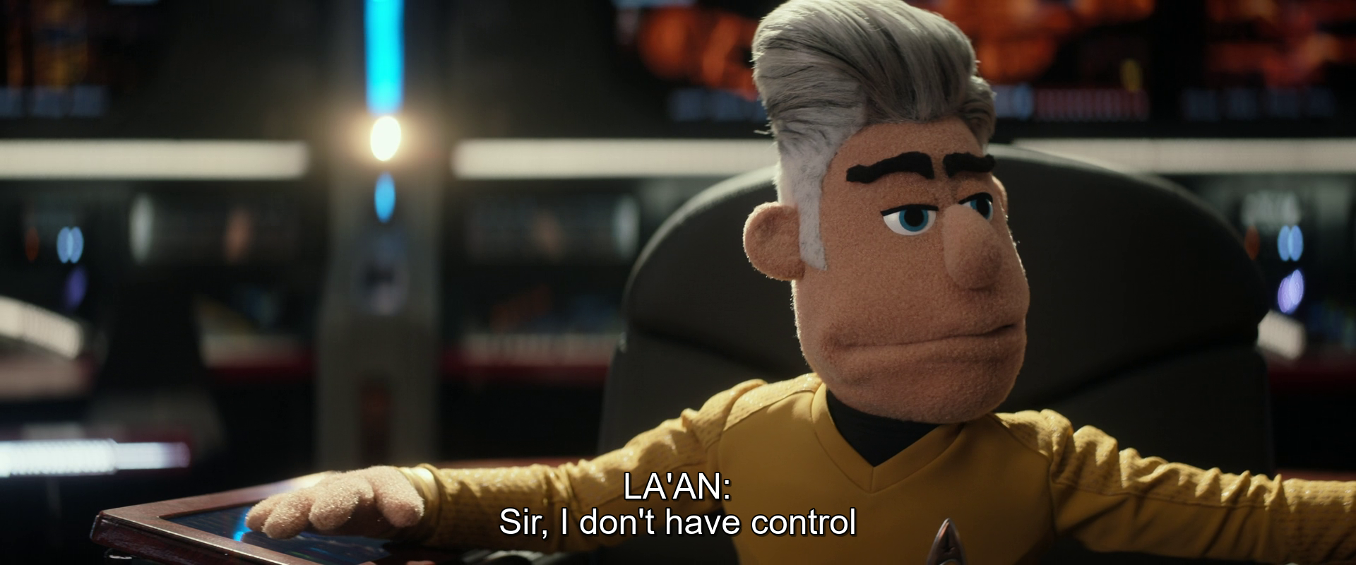 A puppet character dressed in a yellow uniform is sitting in a chair and speaking, saying, Sir, I don't have control.